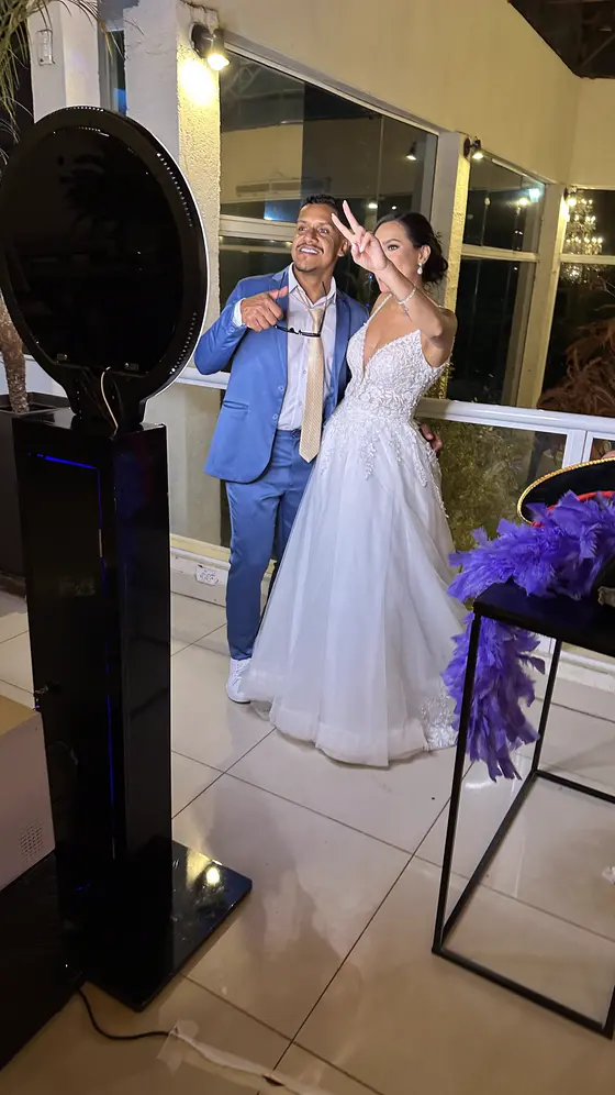 Noivos posando no totem fotográfico em casamento
